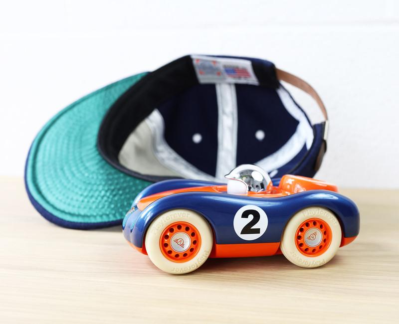 Small cool Vintage orange and blue chrome driver helmet Playforever viglietta Jasper side view by a baseball cap